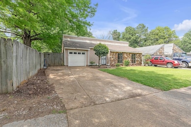 Mid-century home featuring driveway, a shingled roof, and a garage