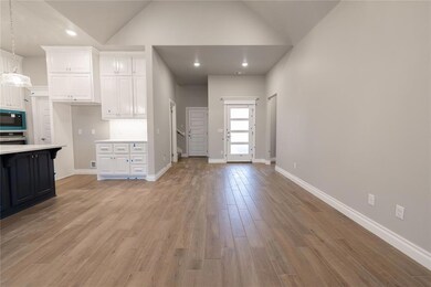 Kitchen featuring high vaulted ceiling, built in m