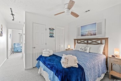 Bedroom featuring light colored carpet, baseboards, rail lighting, and ceiling fan. Wall could be added back to provide privacy.
