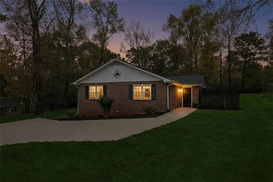Single story home featuring a lawn, brick siding, and driveway