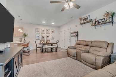 Living room featuring light wood-style flooring, recessed lighting, and ceiling fan