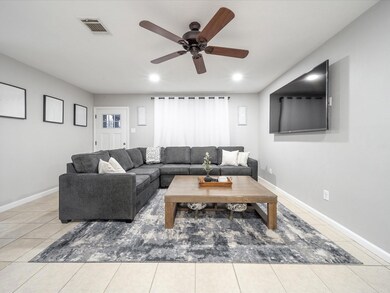 Tiled living room featuring ceiling fan