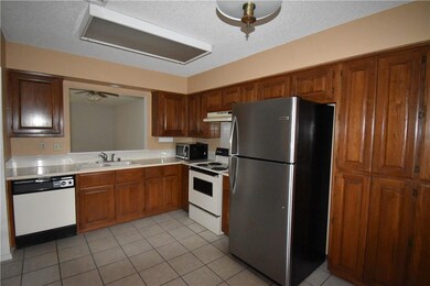 Stainless Steel refrigerator and counter microwave stay with townhouse.