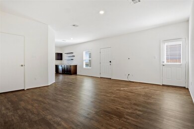 Unfurnished living room with dark wood-style floo