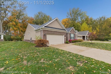 Ranch-style house with a front lawn, brick siding, driveway, and a garage