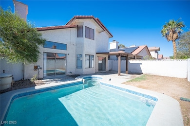 Rear view of property with a tiled roof, a fenced backyard, a patio area, and stucco siding