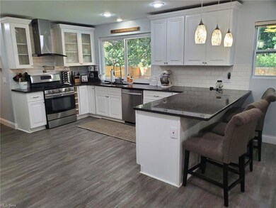 Kitchen featuring subway tile, chimney range hood,