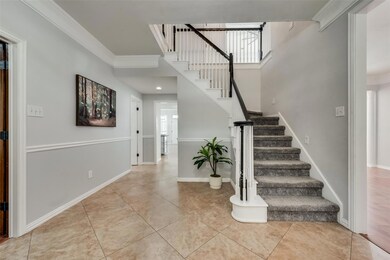 Staircase with ornamental molding and light tile floors