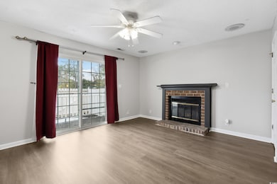 Unfurnished living room with a brick fireplace, ba