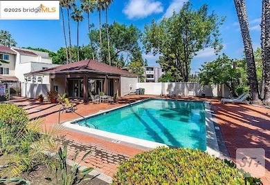 Community pool with a patio area and a fenced backyard