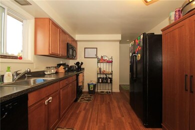 The kitchen has a newer wood floor, cabinets, coun
