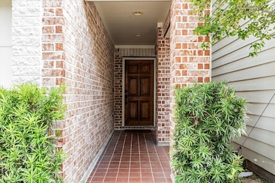 Paved entrance with front landscaping and solid wo