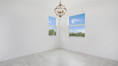 Spare room with a chandelier and baseboards