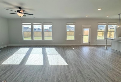 Unfurnished living room featuring baseboards, dark