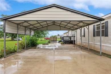 View of covered carport and concrete driveway
