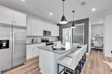 Kitchen with white cabinetry, visible vents, and a