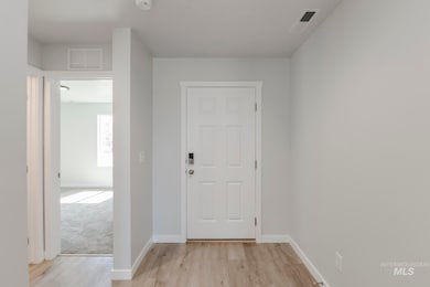 Entrance foyer with light wood-type flooring and baseboards