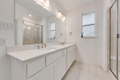 Bathroom featuring tile patterned flooring, vanity, and walk in shower