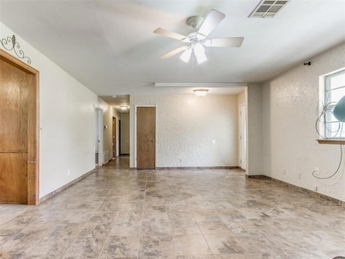 Unfurnished room with visible vents, a ceiling fan