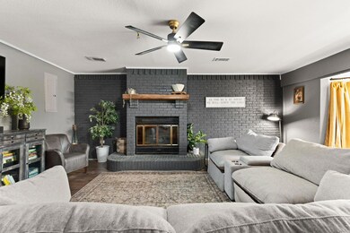 Living room with ceiling fan, a brick fireplace, 