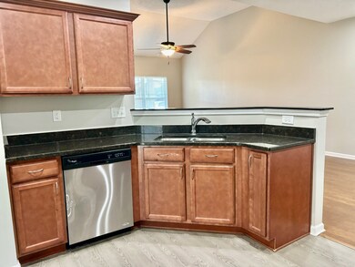 Walk into a open kitchen with granite counter tops, pantry, stainless steel appliances remaining including a refrigerator.