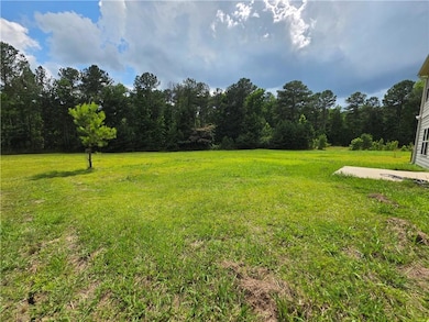 View of grassy yard featuring a wooded view