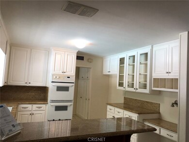 Upgraded kitchen features double ovens, cabinets galore and convenient desk