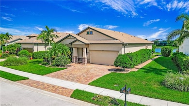 View of front of house featuring a tile roof, a garage, decorative driveway, a front yard, and stucco siding