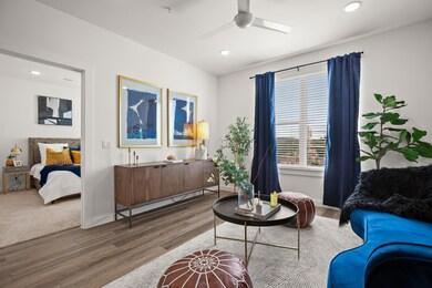 Sitting room with a ceiling fan, wood finished fl