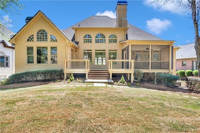 Back of property with a wooden deck and a lawn