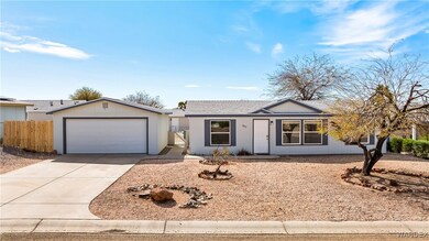 Ranch-style home with a garage, fence, and drivewa