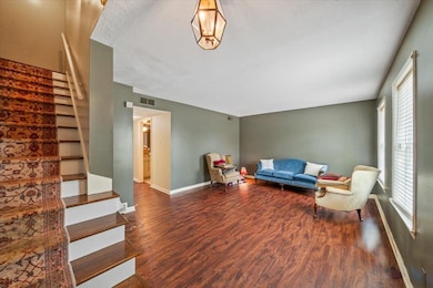 Living area featuring stairs, wood finished floors, and a textured ceiling