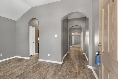 The open floor plan with elegant arched doorways creates a seamless flow throughout the home, adding a touch of sophistication to the living space.