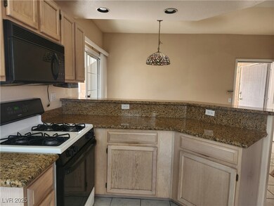 Kitchen featuring black microwave, gas range oven,