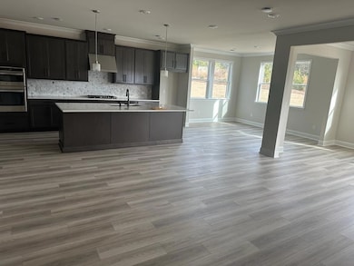 Kitchen featuring double oven, gas cooktop, basebo