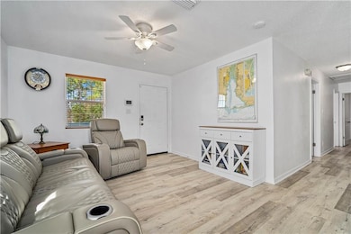 Living room featuring ceiling fan, light hardwood 