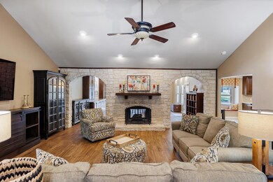 Living room featuring arched walkways, ceiling fa