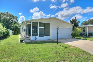View of front facade with driveway, a sunroom, and a garage