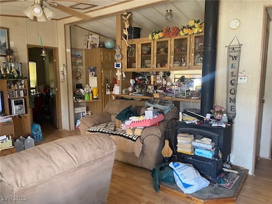 Living area featuring a wood stove, ceiling fan, w
