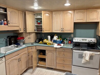Kitchen featuring open shelves, white appliances, and light brown cabinets