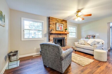 Living room featuring brick wall, ceiling fan, a f