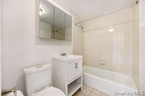 Bathroom featuring vanity, washtub / shower combination, and light tile patterned floors