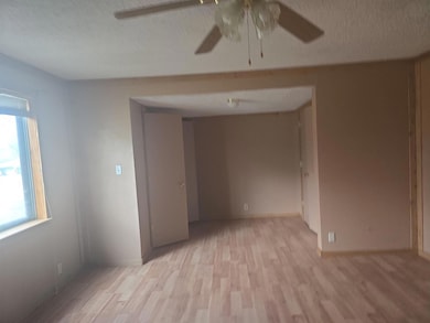 Empty room featuring a textured ceiling, light woo