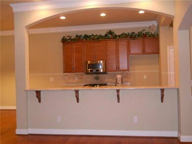 Architectural details abound throughout this home.A  long bar separates the den from the kitchen.