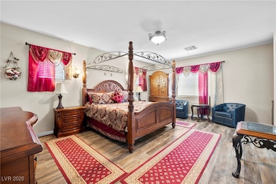 Primary bedroom featuring wood finished floors and multiple windows