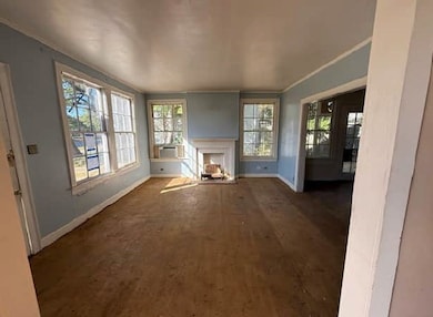 Unfurnished living room featuring a fireplace and crown molding
