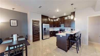 Kitchen with light countertops, a breakfast bar, visible vents, a peninsula, and appliances with stainless steel finishes