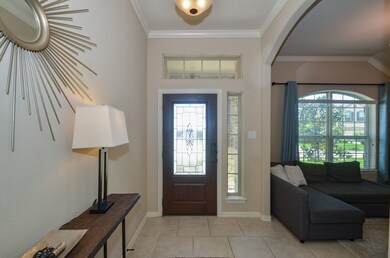 Entrance with lots of natural light, tile flooring and crown molding.