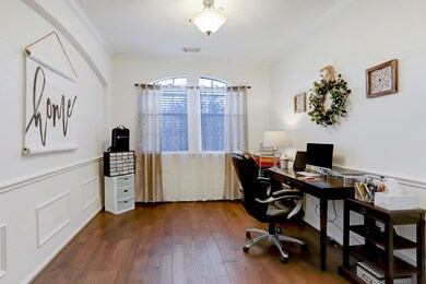 Dining Room currently used as a second home office.  Imagine making memories gathered around the dining table with your family and friends! This dining room has high ceilings, crown molding, elegant chair rail and wainscoting, wood flooring and windows for natural light.  Conveniently accessible from the living room and with easy access to the kitchen.