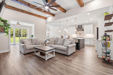 Living area featuring a ceiling fan, beam ceiling, light wood-type flooring, and recessed lighting